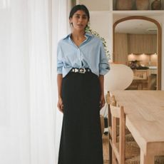 Monikh wearing a black pencil skirt and blue shirt