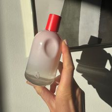 Hand holding Glossier You perfume