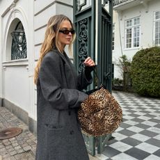 Anna Winck in a grey trench coat and an Isabel Marant leopard handbag.