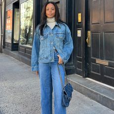 Sierra mayhew is wearing a white turtleneck, denim jacket, jeans and chain handbag.